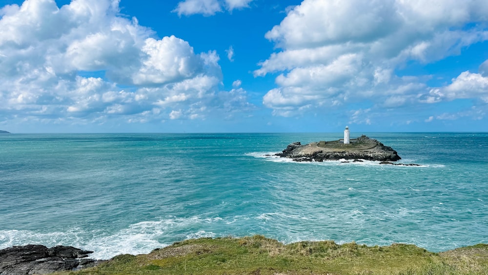 a lighthouse on an island in the middle of the ocean