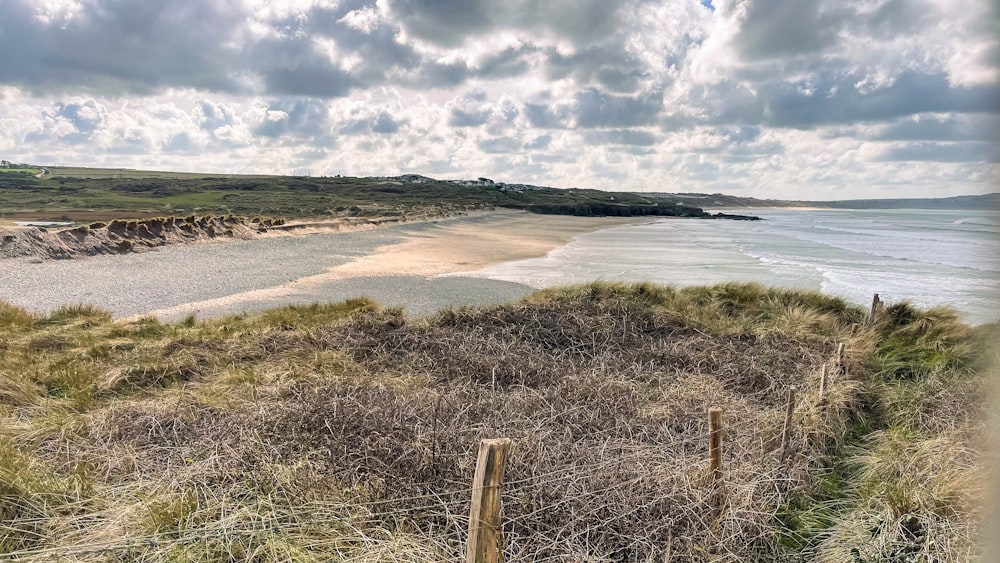 a view of a beach from a grassy hill