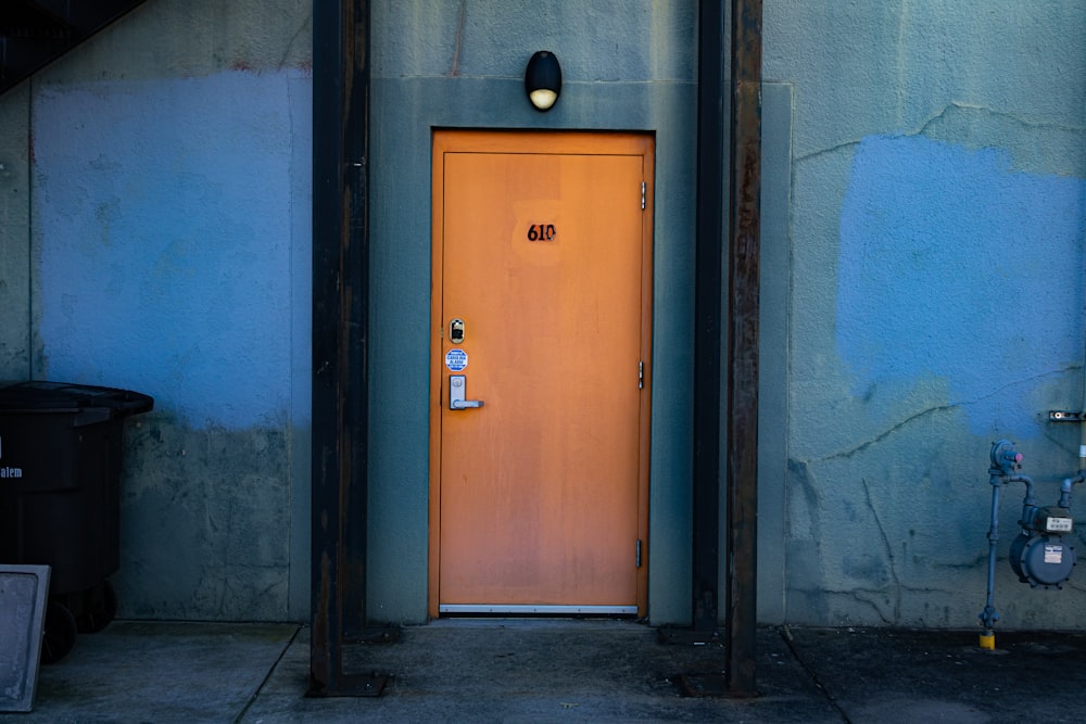 an orange door sits in front of a blue wall
