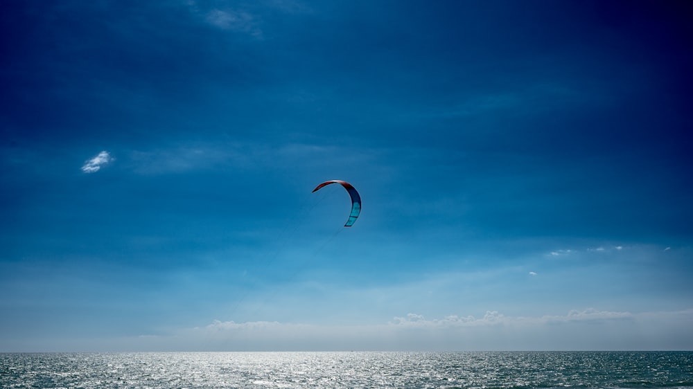 a kite flying over the ocean on a sunny day