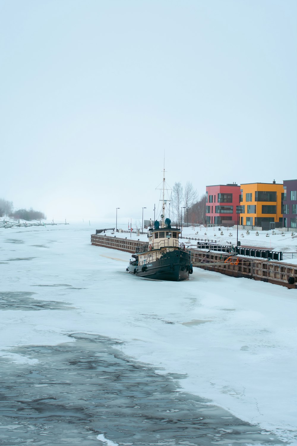 a couple of boats floating on top of a frozen river