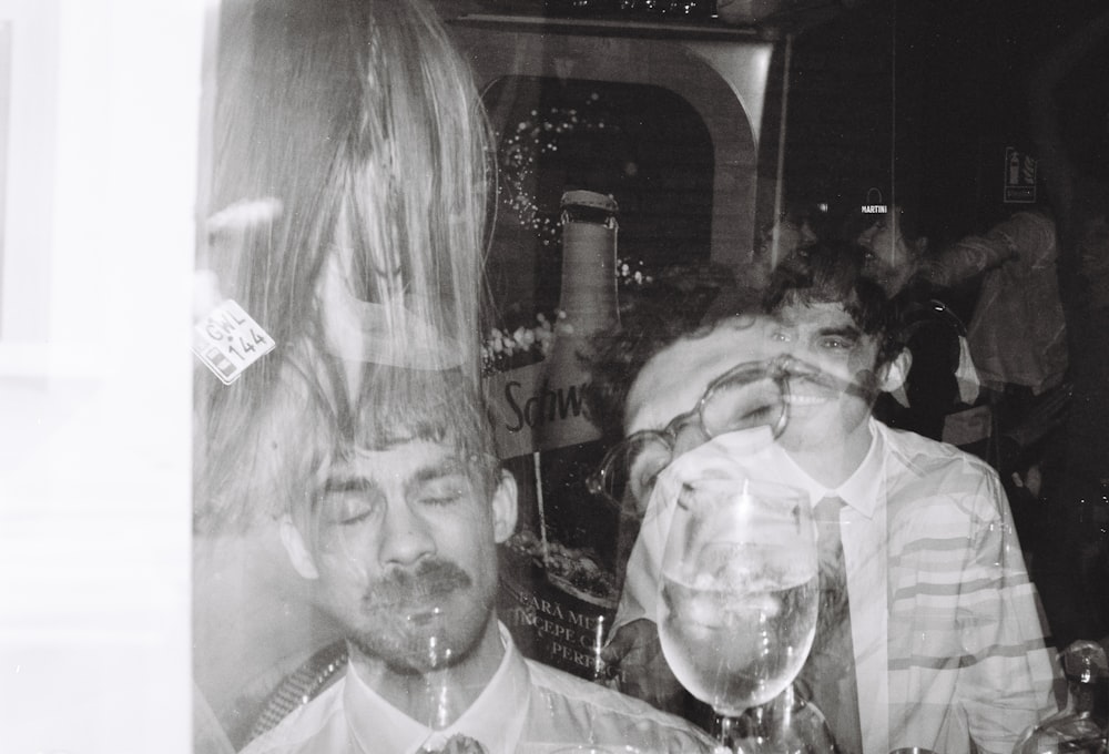 a black and white photo of people drinking wine