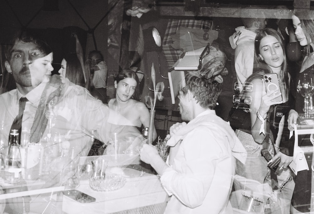 a group of people standing around a table