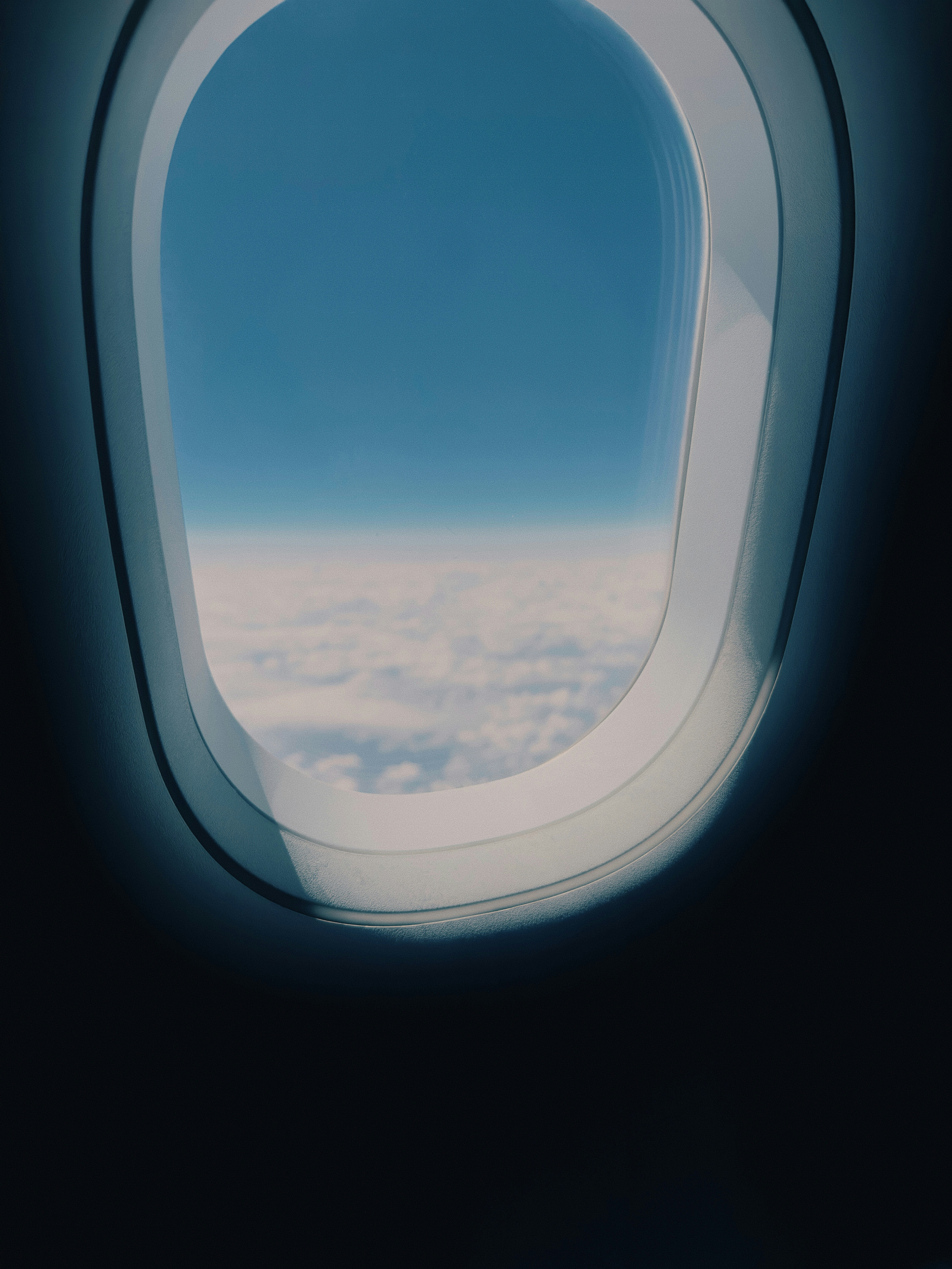 an airplane window with a view of the clouds below