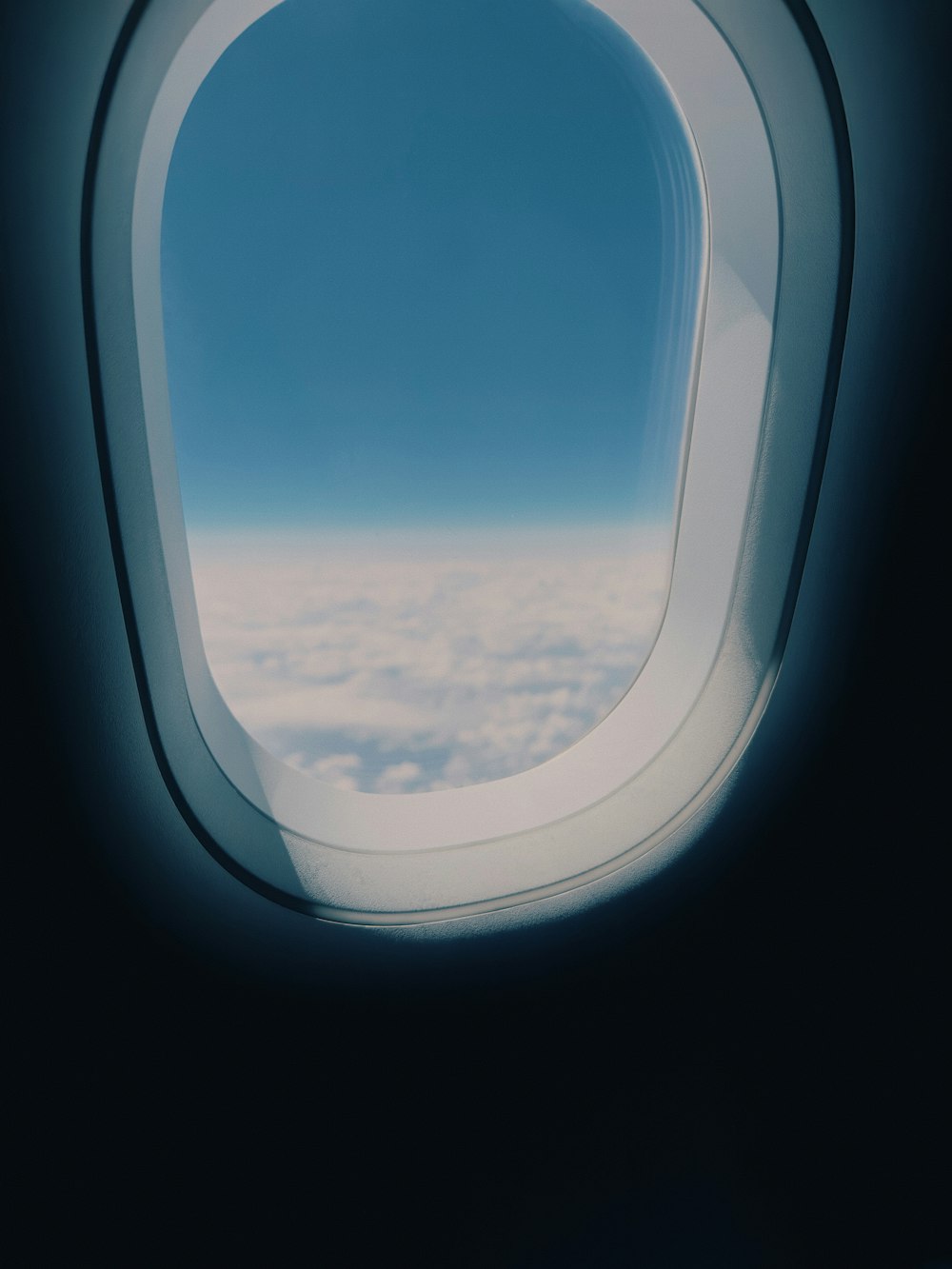an airplane window with a view of the clouds below