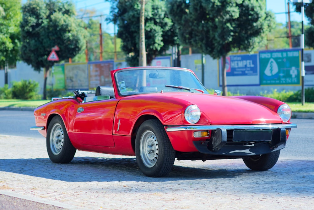 un'auto sportiva rossa parcheggiata sul ciglio della strada