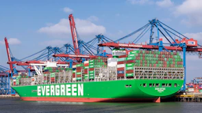a large green cargo ship in a harbor