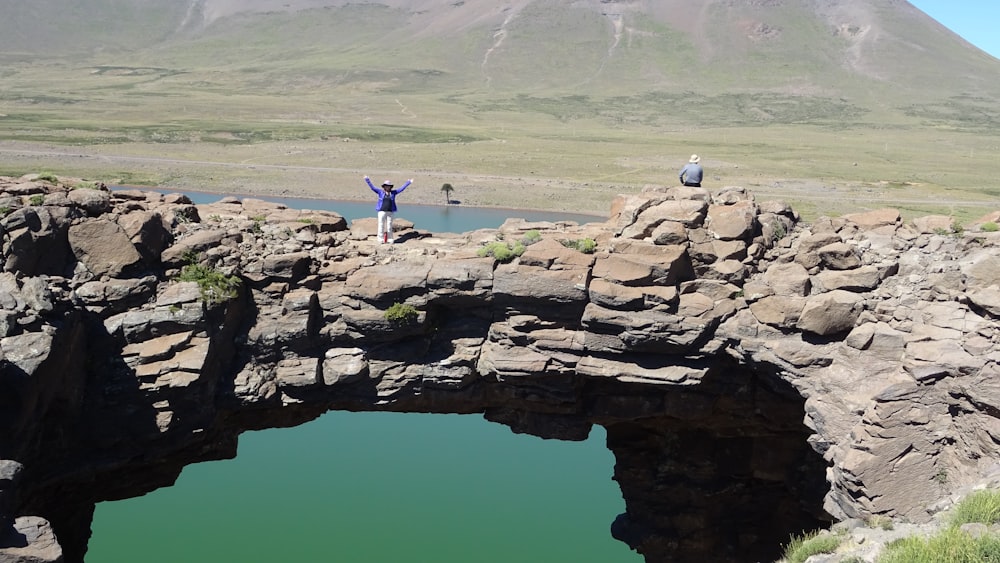 a person standing on a bridge over a body of water