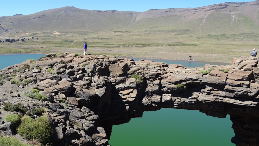 a person standing on a bridge over a lake