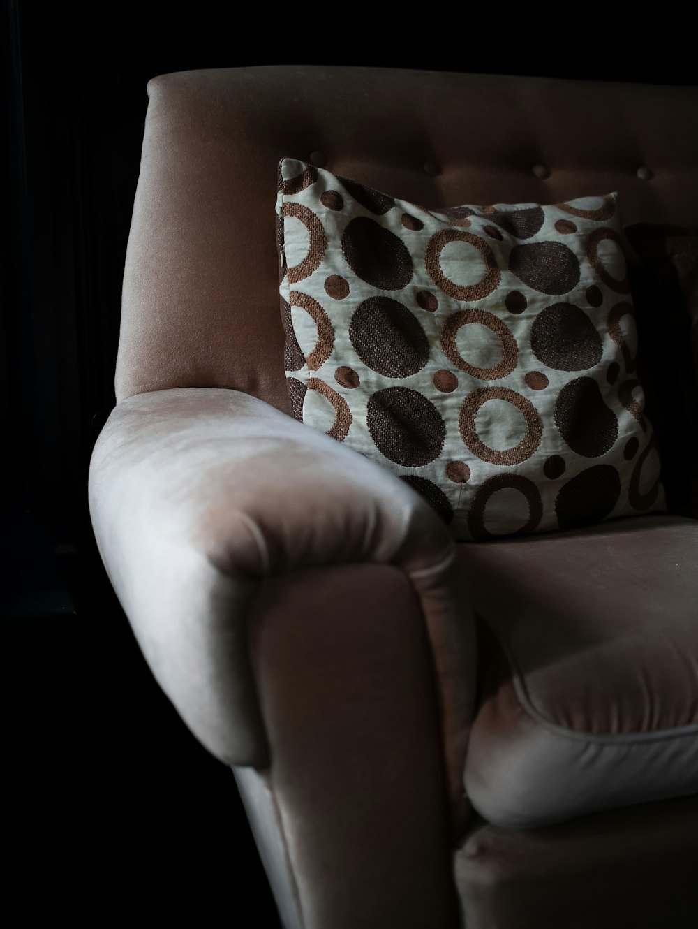a brown and white pillow sitting on top of a chair