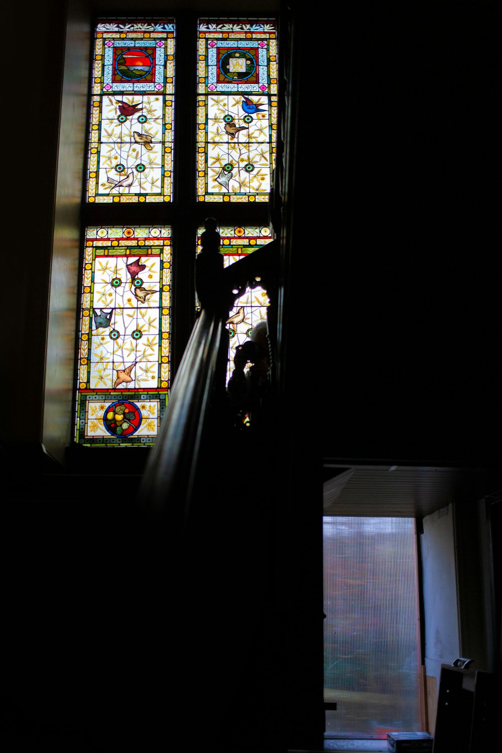 a person standing in front of a stained glass window