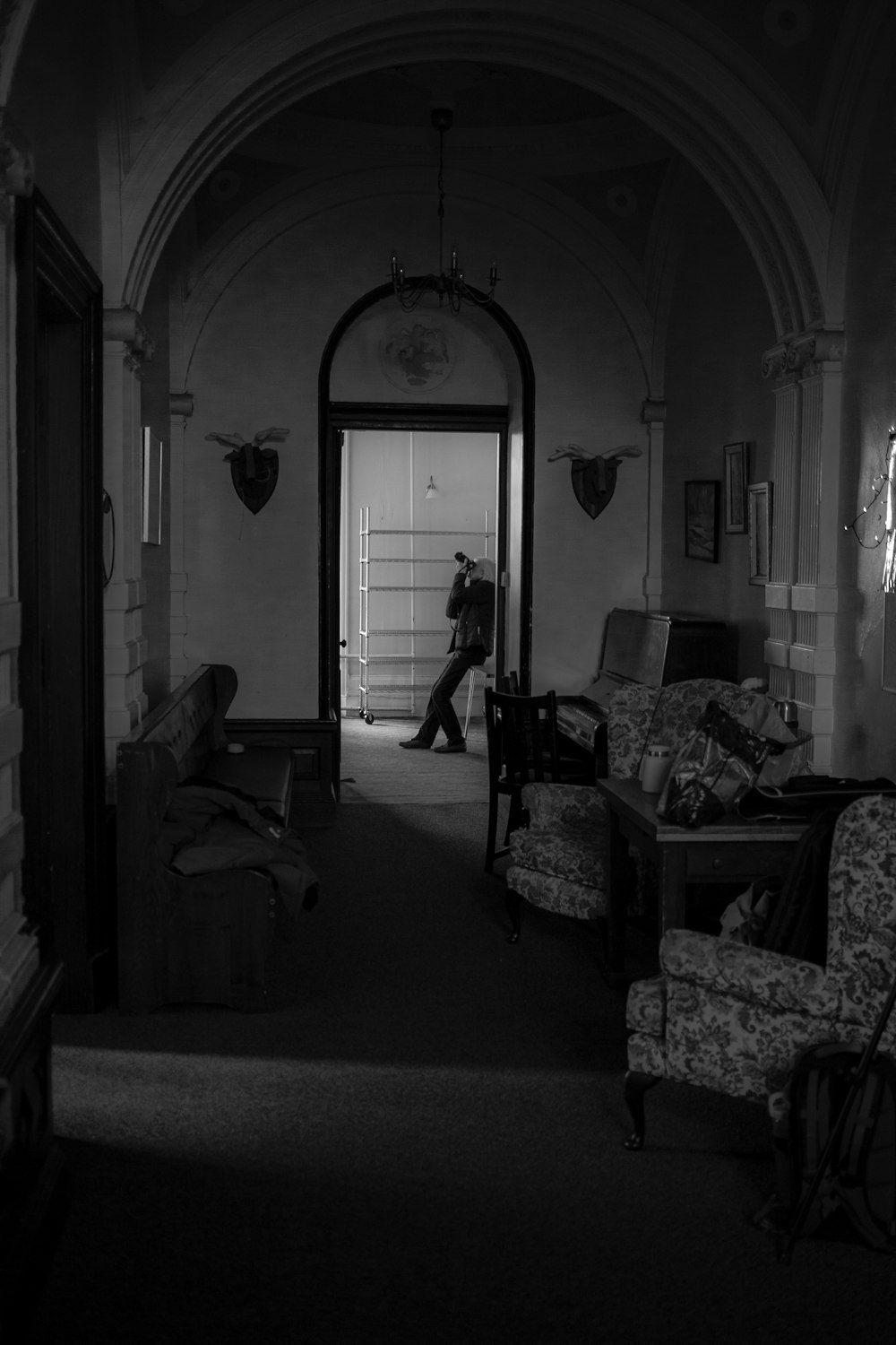 a black and white photo of a person walking into a room