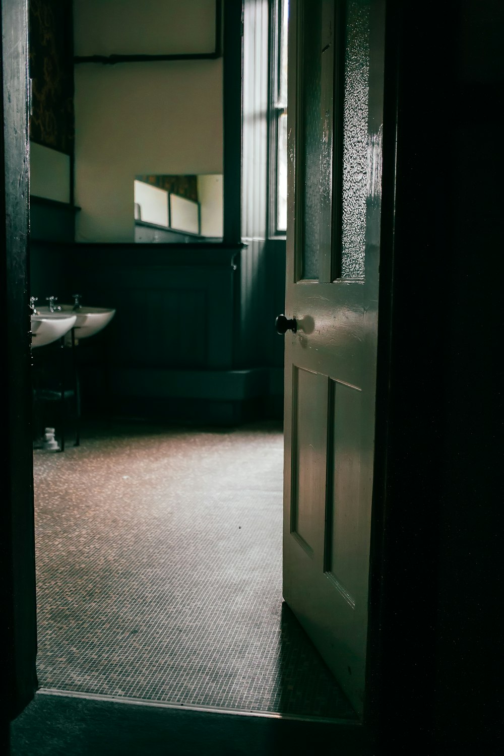 an open door leading to a bathroom with a sink