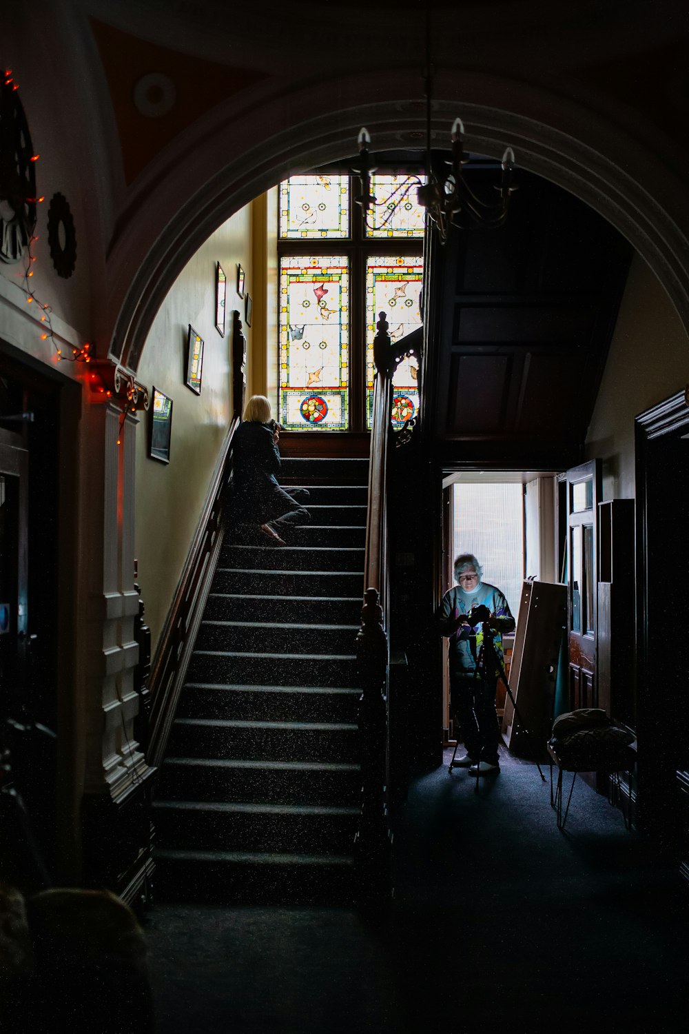 a man sitting on a stair case next to a window