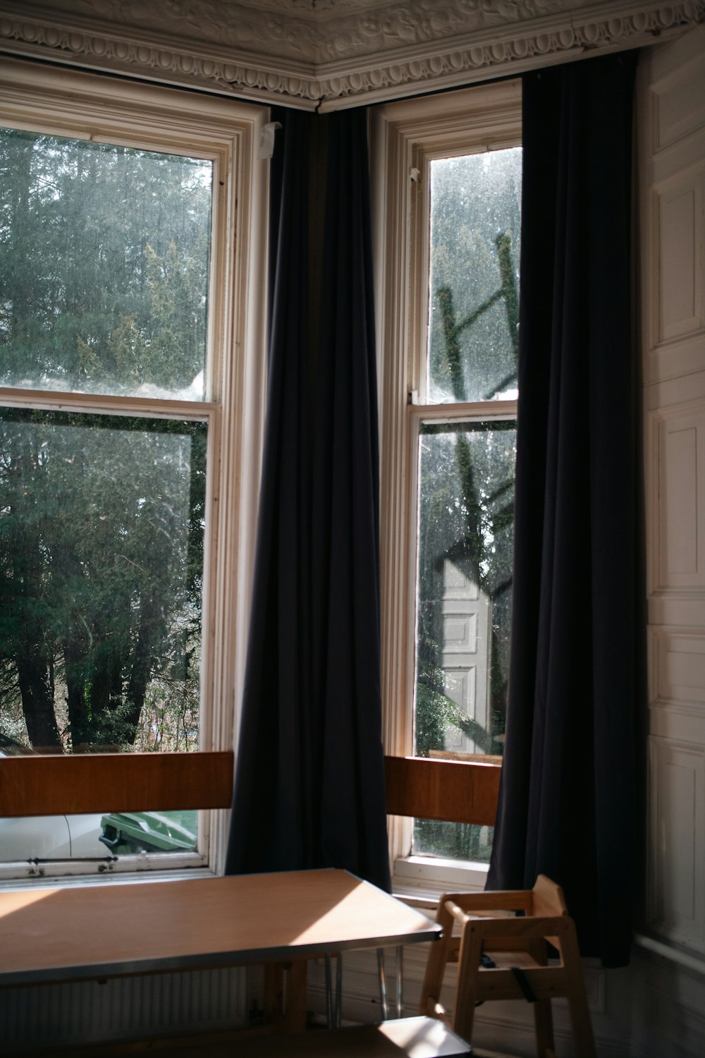 a wooden table sitting in front of a window