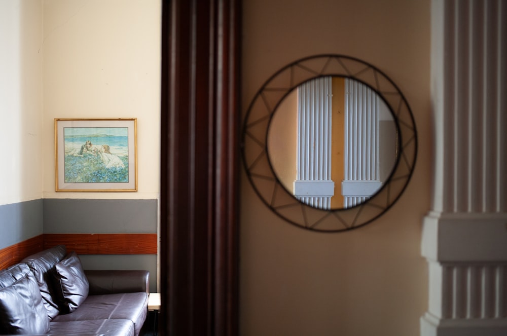 a living room with a couch and a round mirror