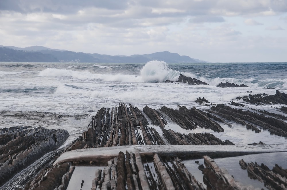 a rocky beach with waves crashing on the rocks