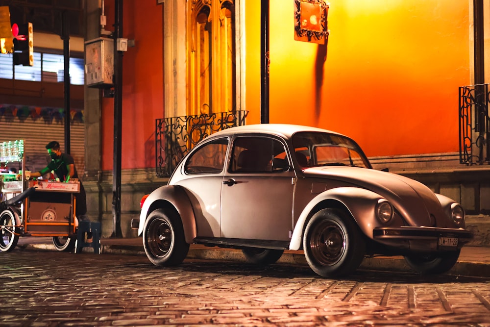 an old car parked on a cobblestone street