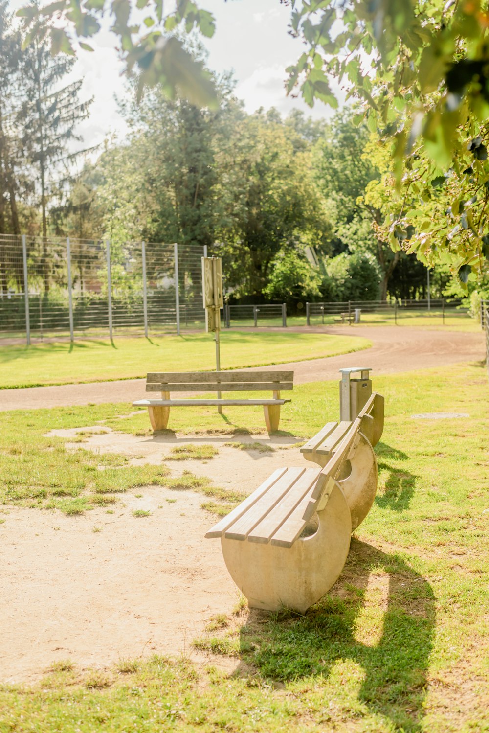 a couple of benches sitting on top of a lush green field