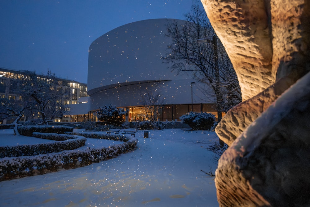 Una noche nevada en una ciudad con un edificio al fondo