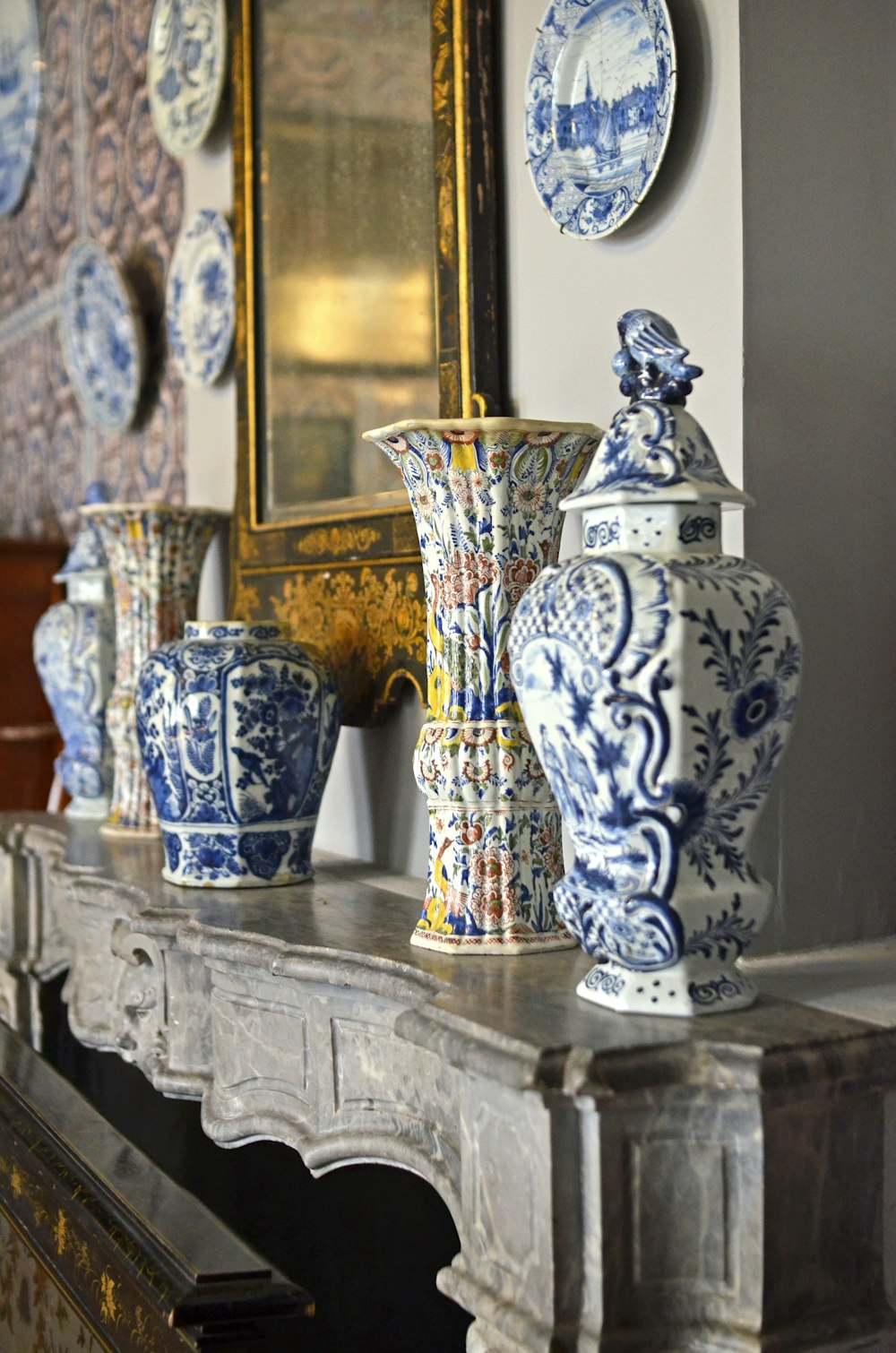 a mantle with blue and white vases on it