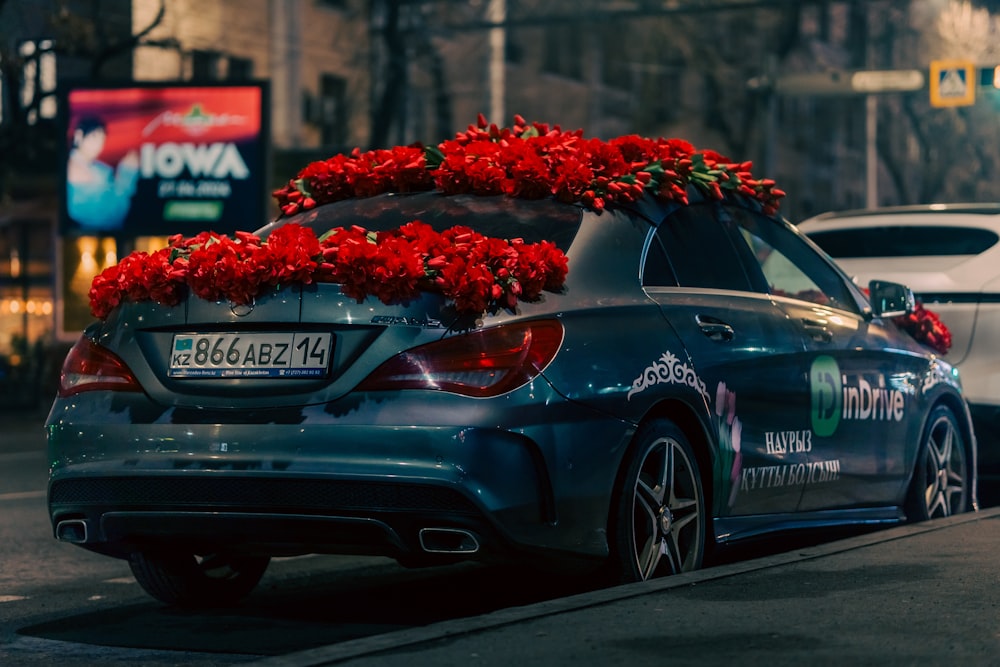 a car with a bunch of red flowers on top of it