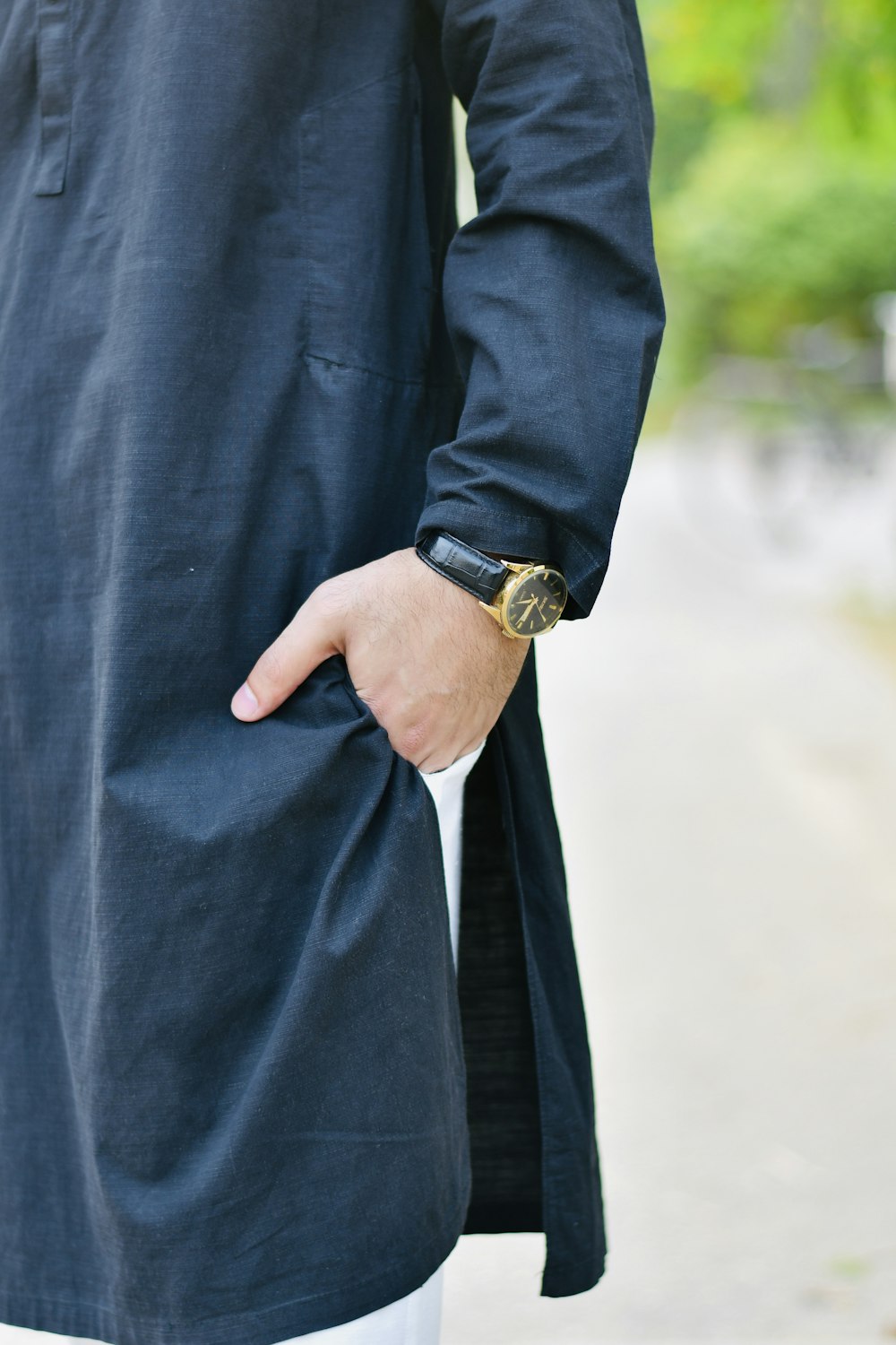a man in a black shirt is holding his hand in his pocket