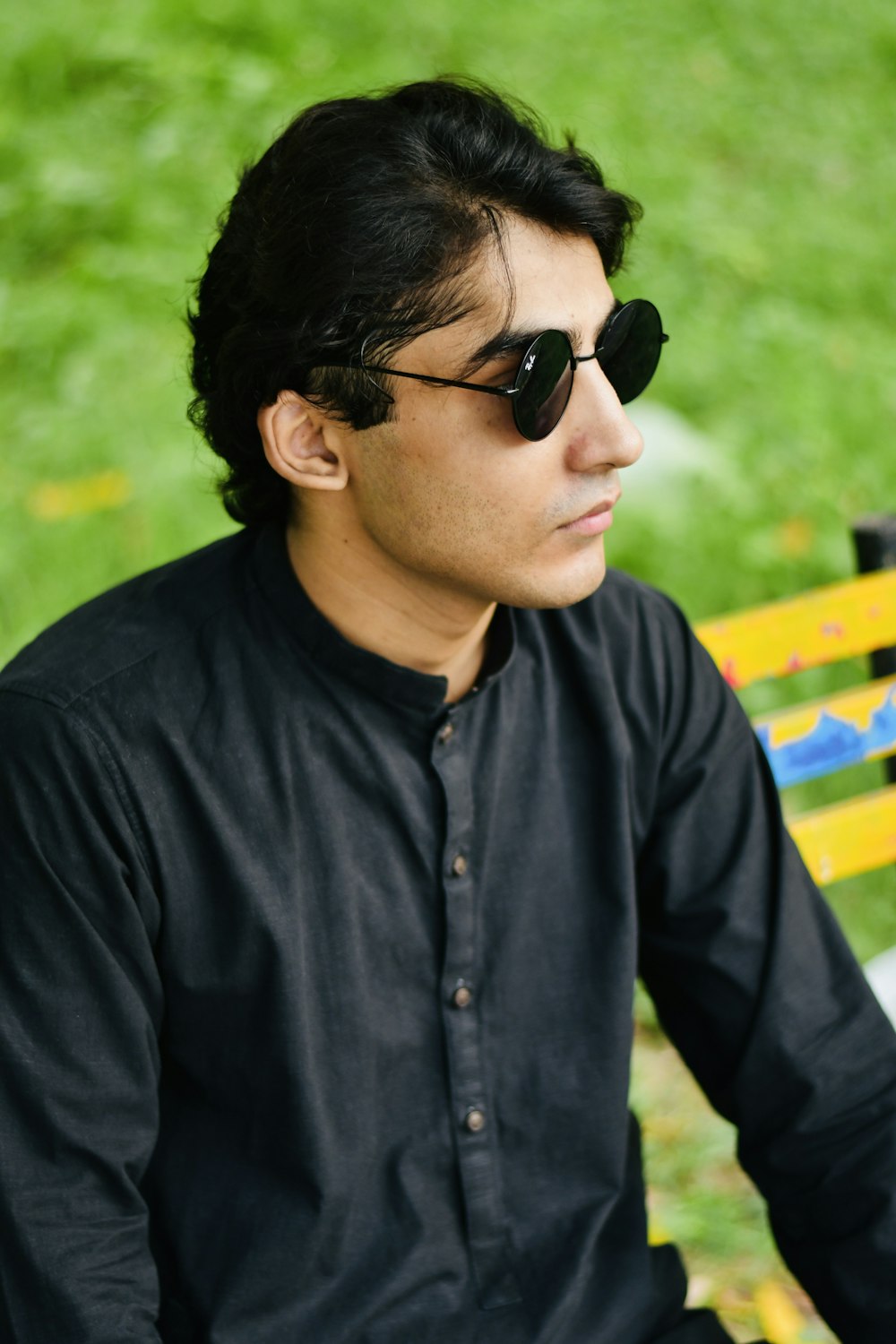a man wearing sunglasses sitting on a bench