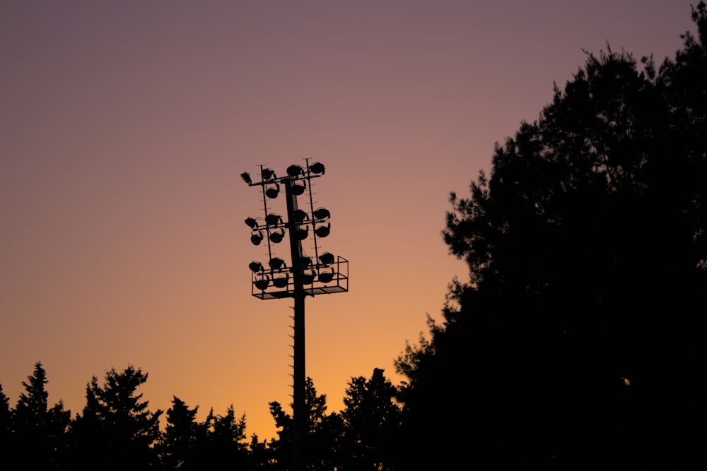 a silhouette of a cell phone tower with trees in the background