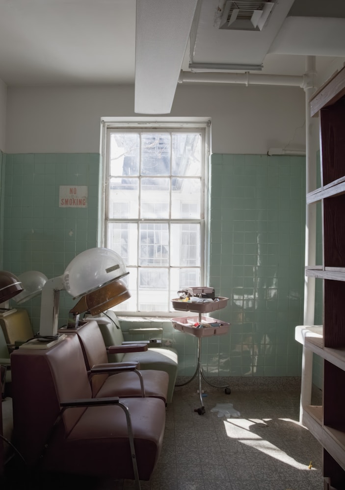 Vintage salon chairs against a green wall