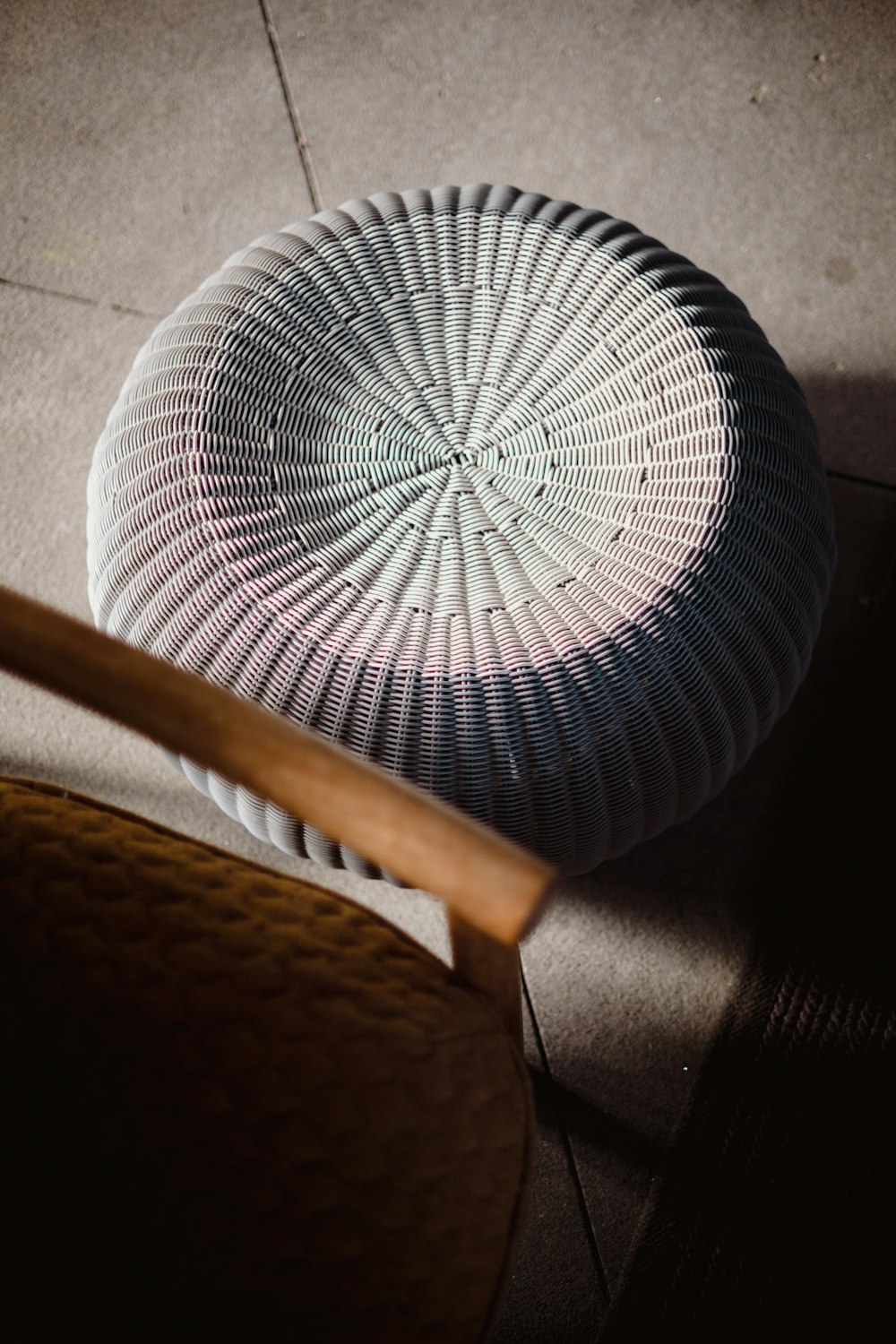 a white basket sitting on top of a wooden chair