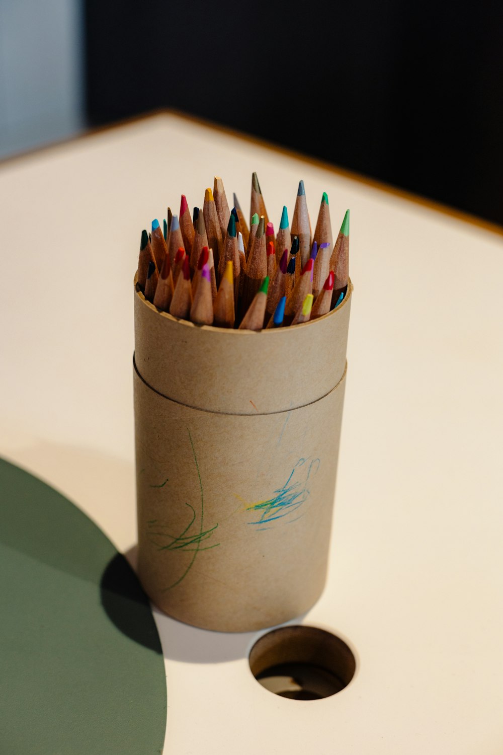 a cup full of colored pencils sitting on a table