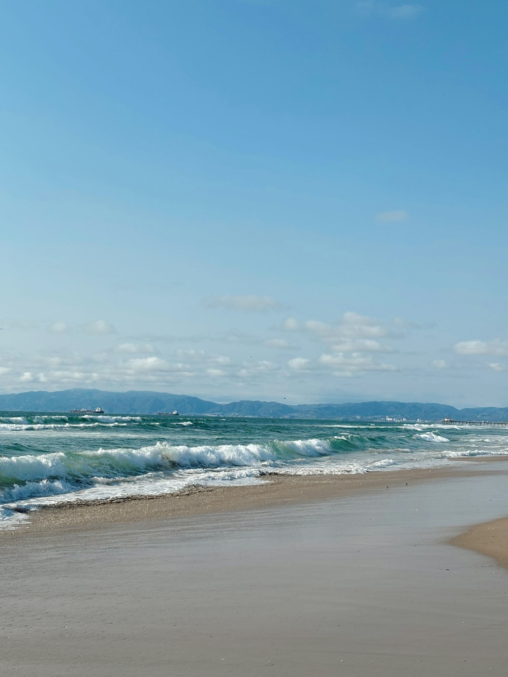 a person walking on the beach with a surfboard