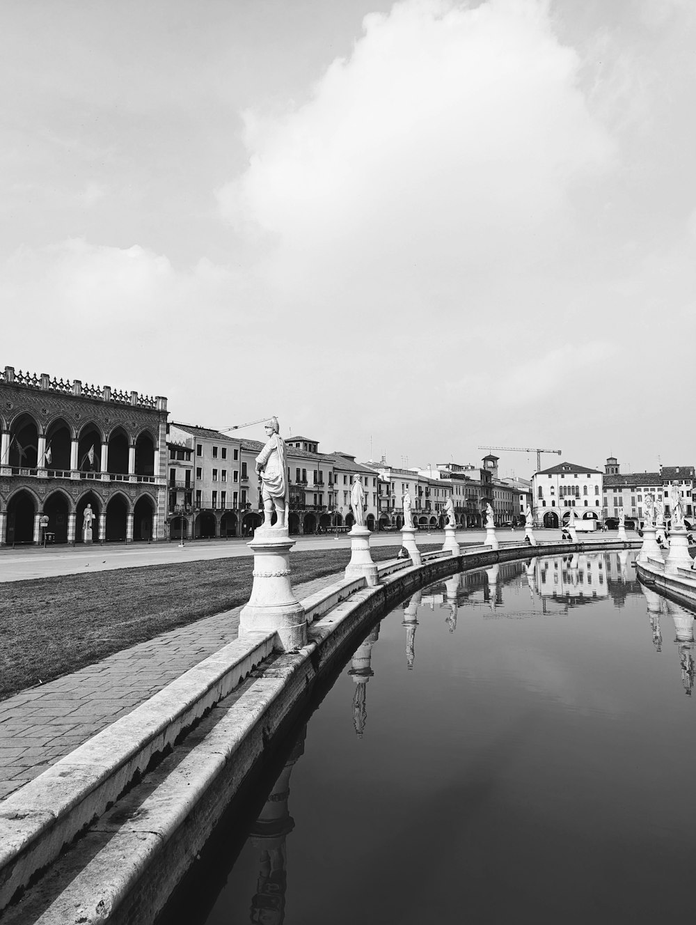 a black and white photo of a pond in a city