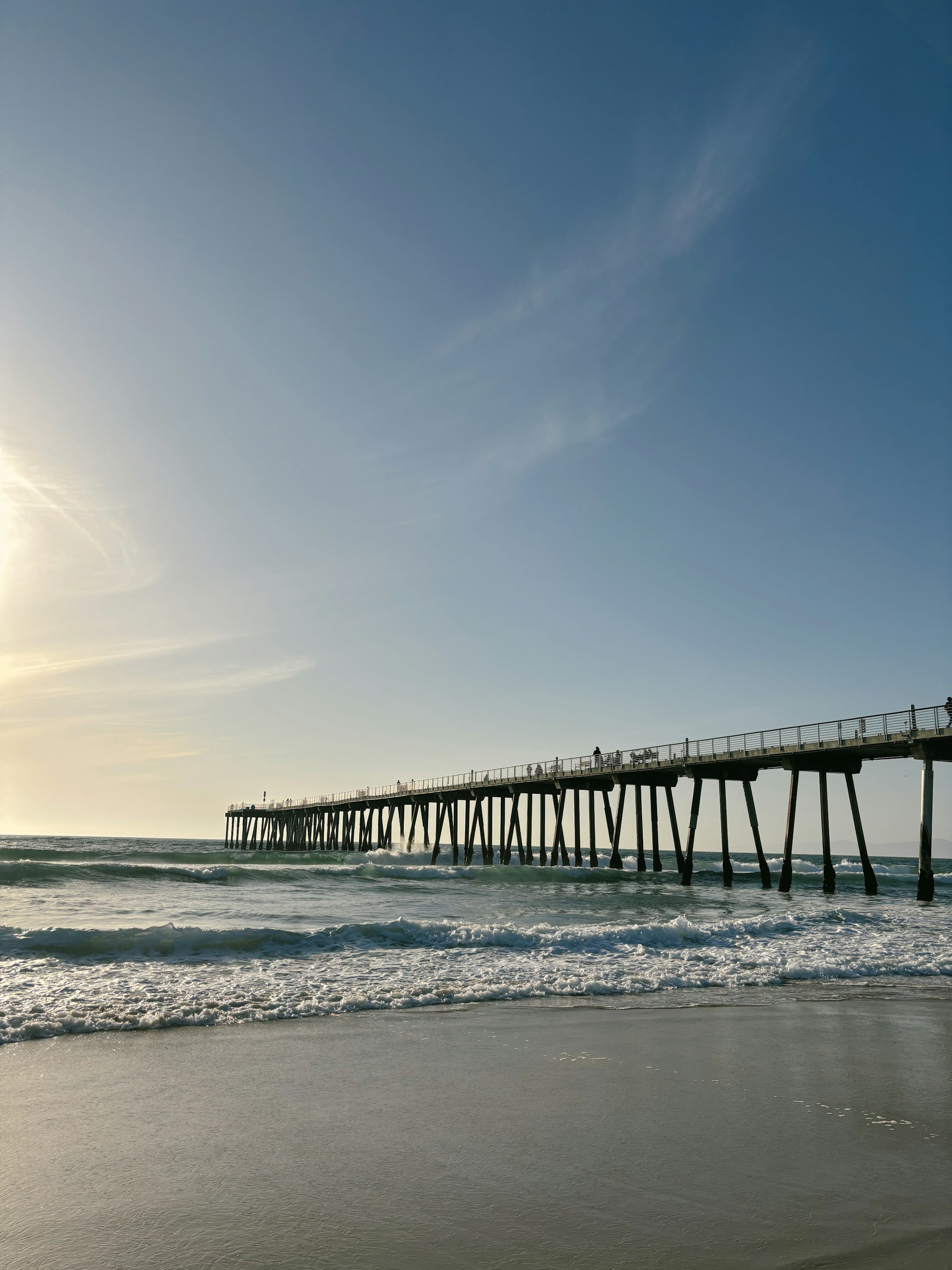 a long pier stretches out into the ocean