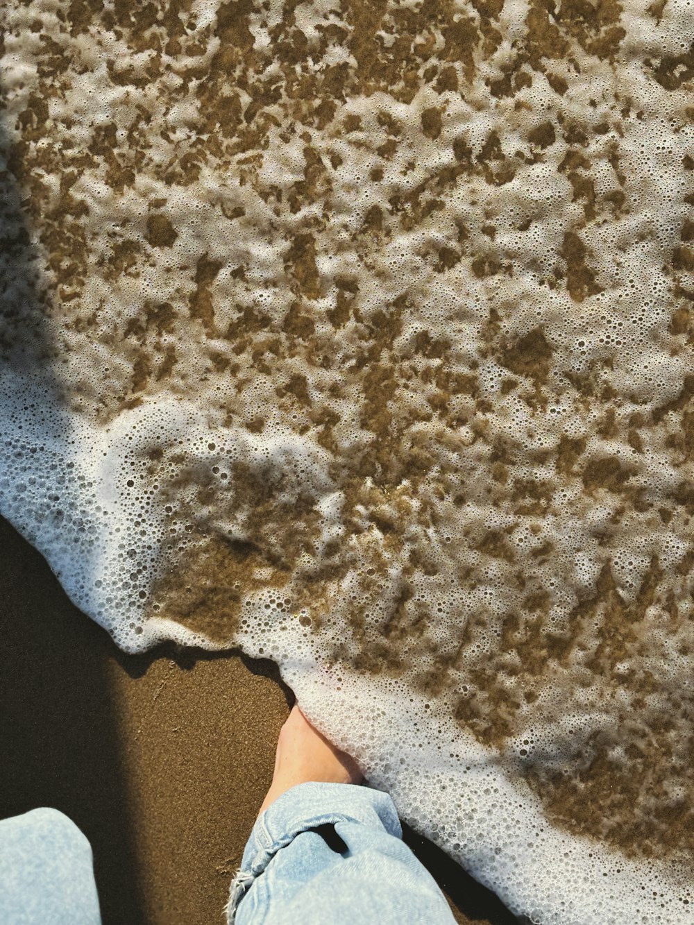 a person standing on a beach next to the ocean