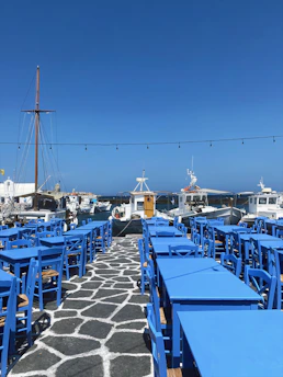 a row of blue tables sitting on top of a stone walkway