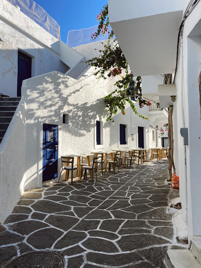 Cobblestone alley with tables and chairs in Lefkes