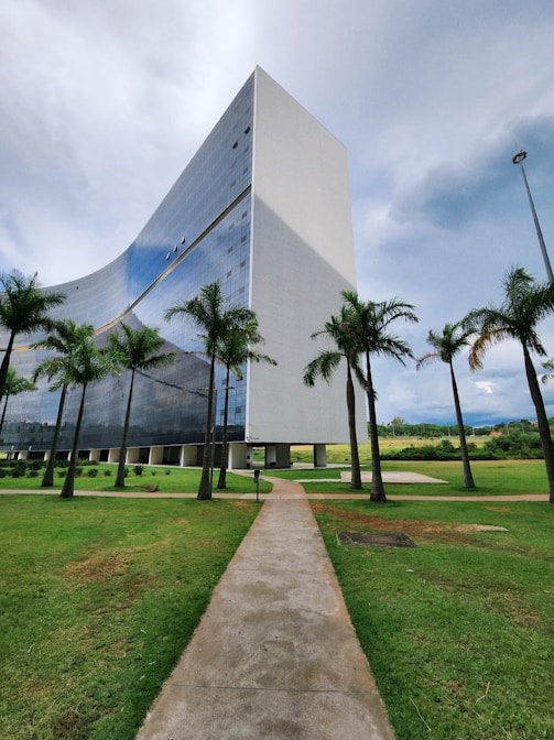 a very tall building sitting in the middle of a lush green field