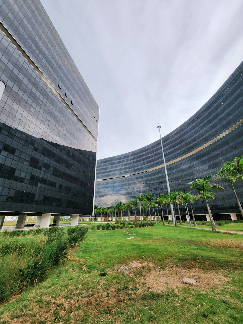 a very large building sitting next to a lush green field