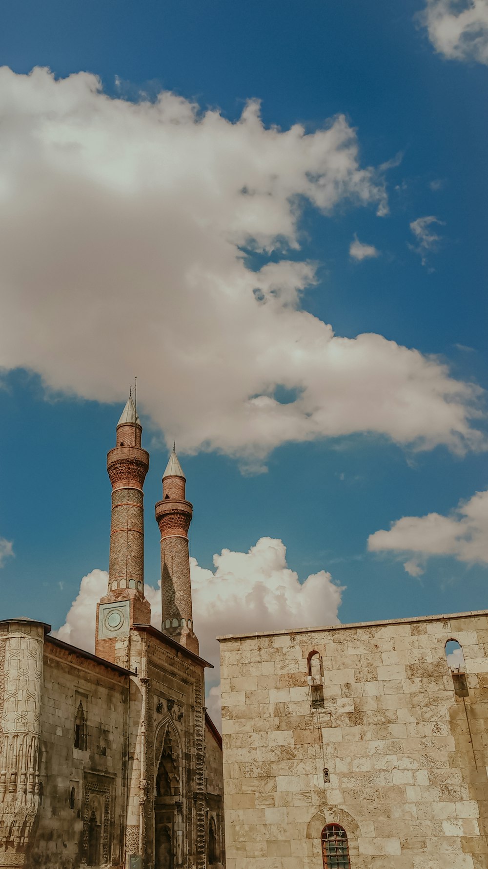 a tall building with two towers under a cloudy blue sky