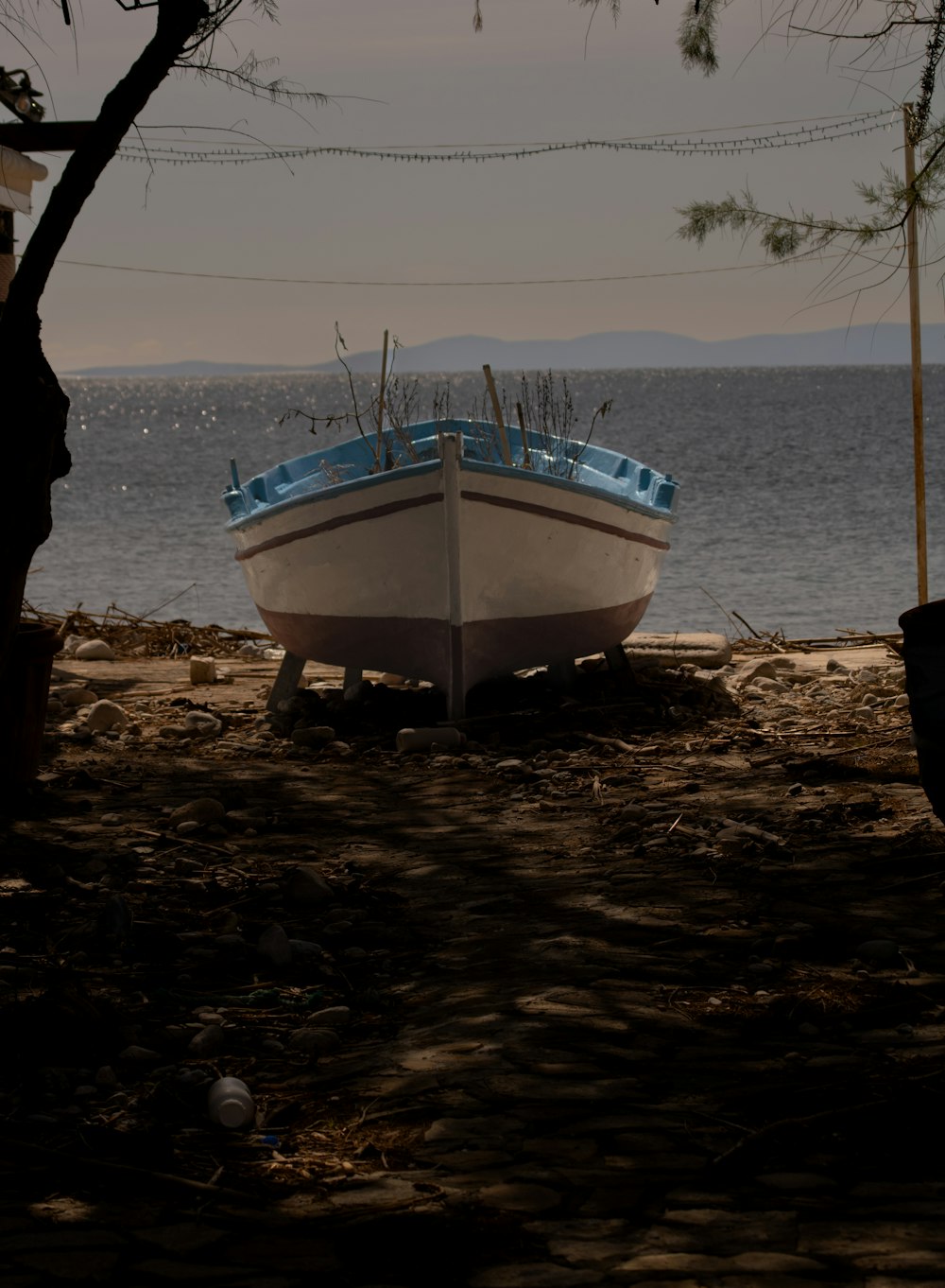 a boat sitting on top of a sandy beach