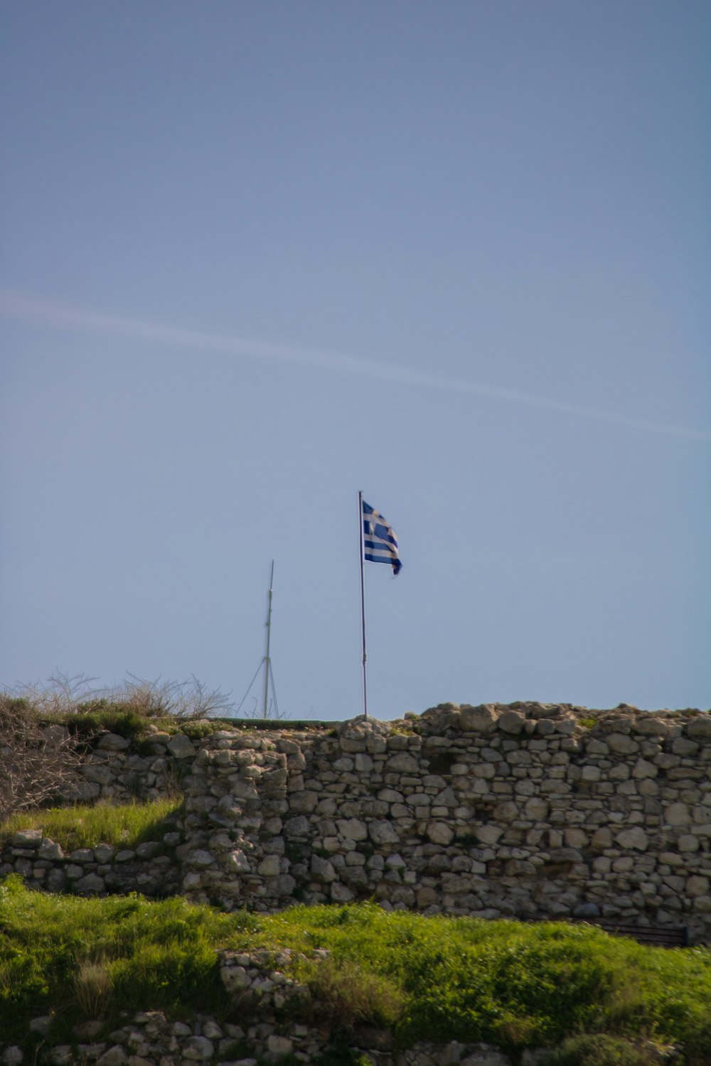 a flag flying on top of a stone wall