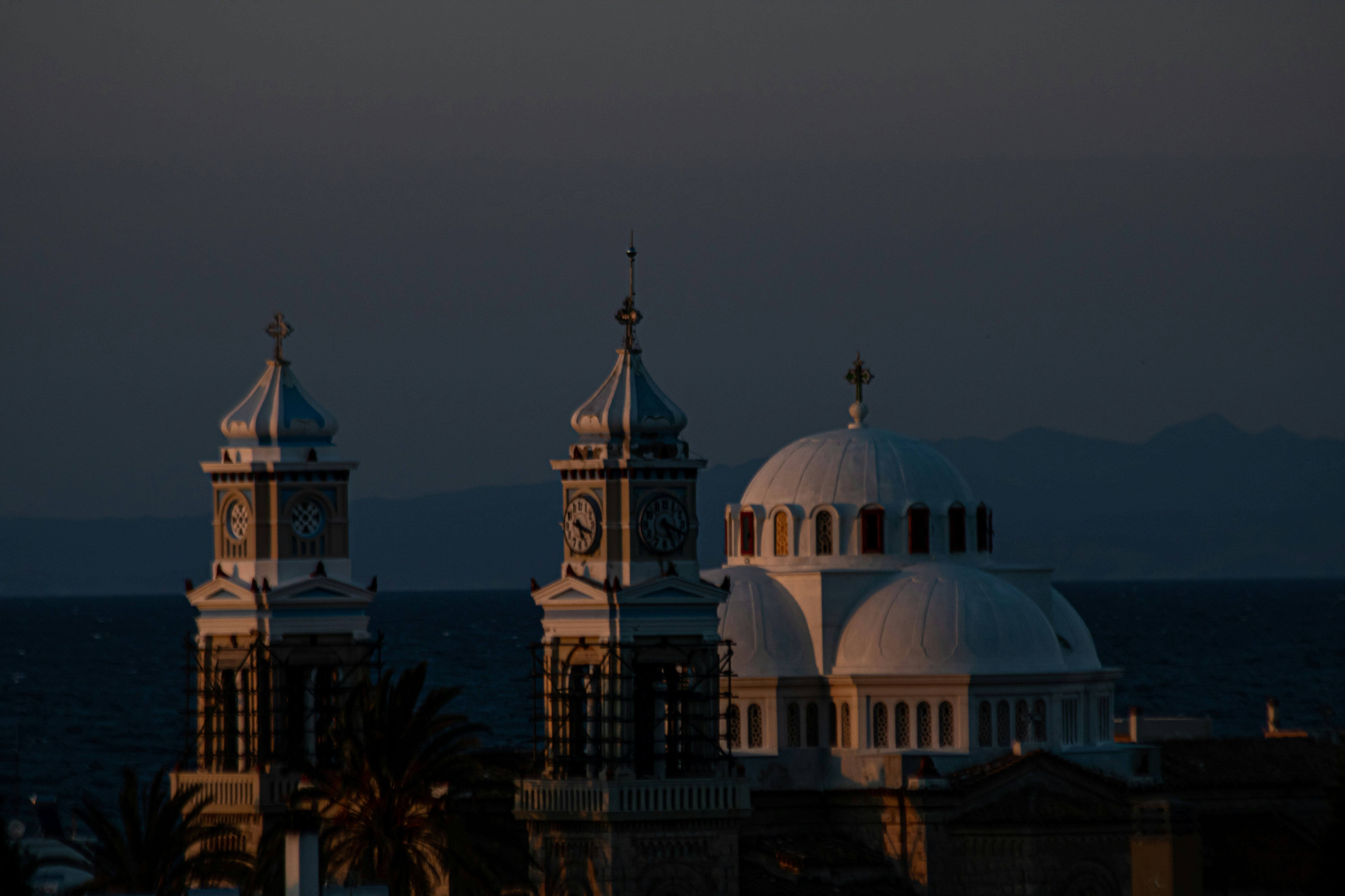 a view of a building with a clock tower in front of a body of water
