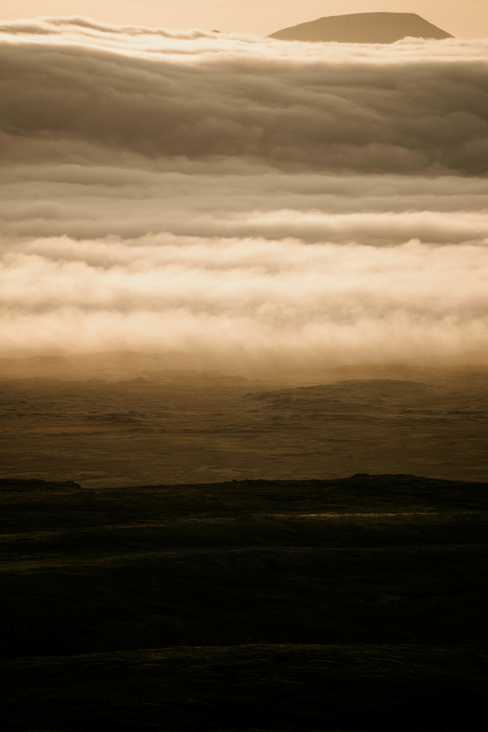 a view of a mountain covered in clouds