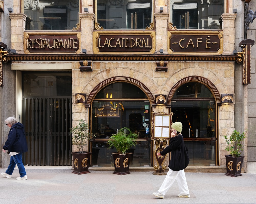 a man walking down a street past a cafe