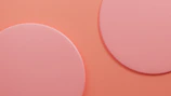 a close up of two circles on a pink background