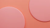 a close up of two circles on a pink background