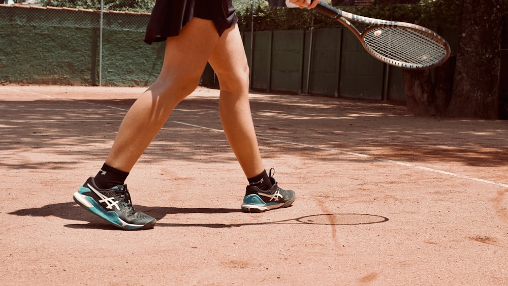 a woman holding a tennis racquet on a tennis court