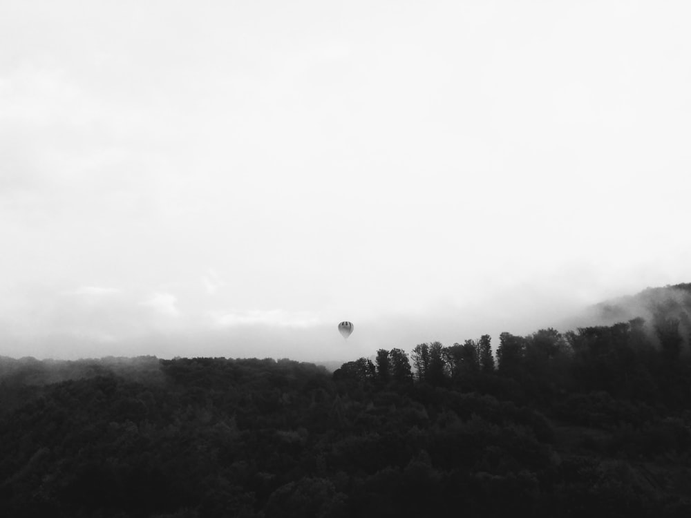 a black and white photo of a hot air balloon in the sky